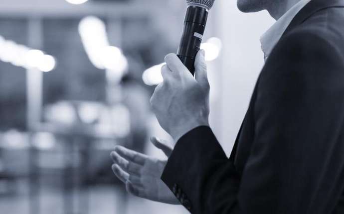 Male presenter in a suit giving speech at a business event