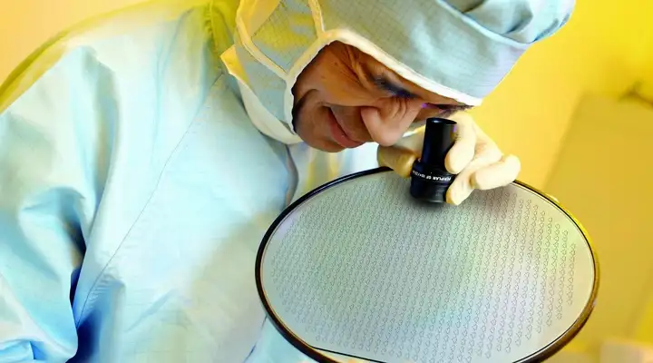 A scientist inspecting a SCHOTT HermeS® Hermetic Through Glass Via (TGV) Wafers