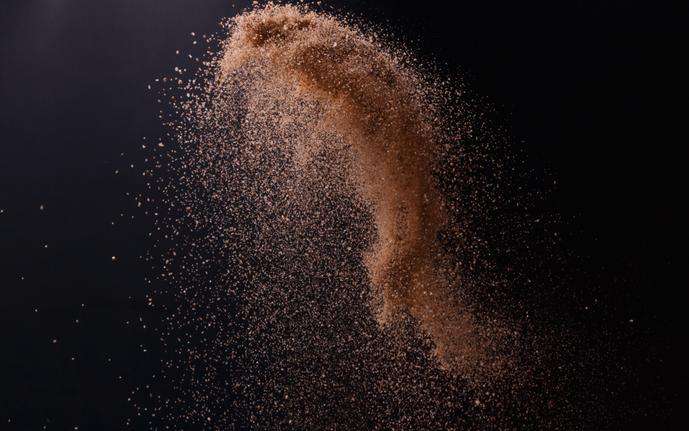 Flying sand as a close-up view in front of a black background