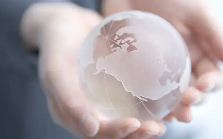 Close up of female hands holding a glass globe