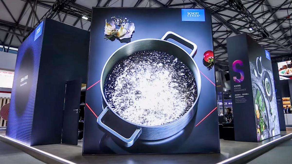 Boiling water in a pot with red illuminated cooking zone on the exhibition booth wall at AWE in Shanghai 