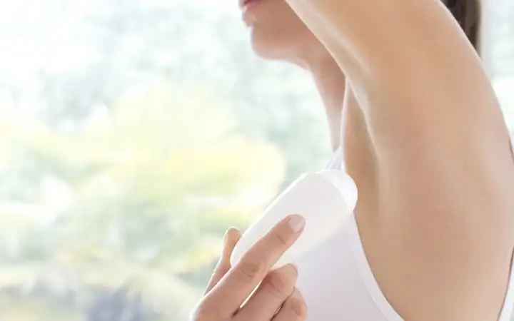 Female applying roll-on deodorant