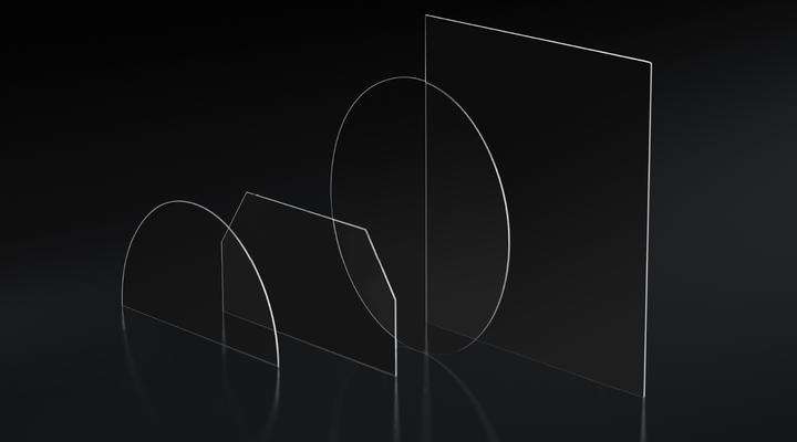 Four clear samples of SCHOTT Cut-to-Size Substrates in different shapes on a dark background