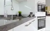 Modern white kitchen with built-in oven and microwave