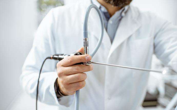Male doctor holding a silver endoscope