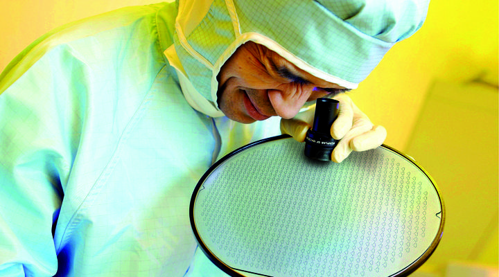 Scientist inspecting a large glass wafer