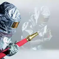 Fire fighter in silver protective suit holding a red water hose