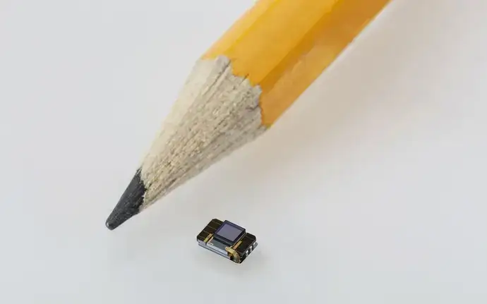 A comparison showing the extreme miniaturization of a pencil compared to a component sealed with SCHOTT Primoceler Glass Micro Bonding