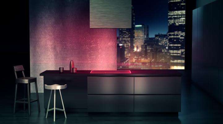 Modern domestic kitchen with dark cupboards and red illuminated SCHOTT CERAN® glass-ceramic cooktop