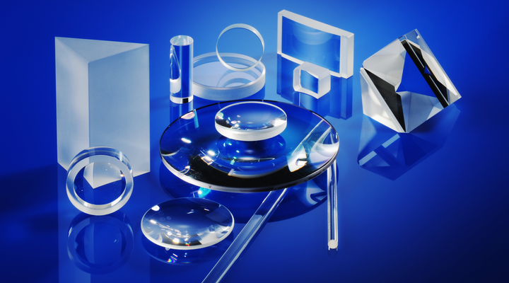 Series of optical components of different shapes and sizes on a blue background