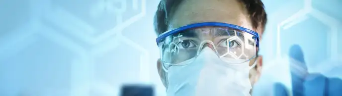 Male doctor in safety glasses looking forwards