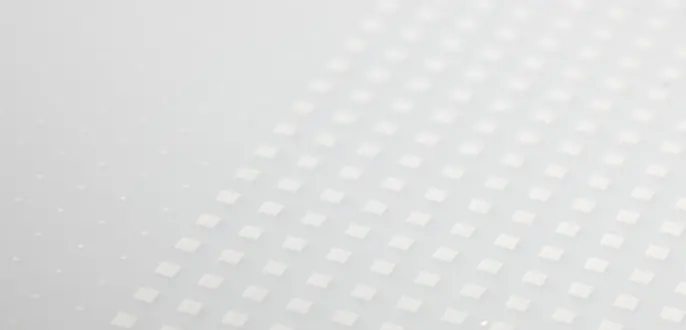 Weiße Glaskeramik mit einem Rastermuster aus kleinen weißen Punkten und Quadraten