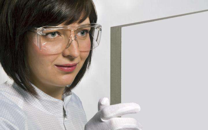 Female scientist examining a sample of PYRANOVA® secure fire-resistant glass