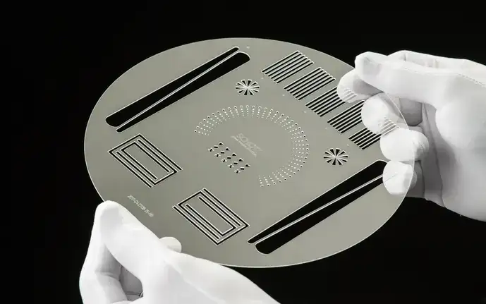 Gloved hands holding a structured glass wafer made from SCHOTT FLEXINITY®