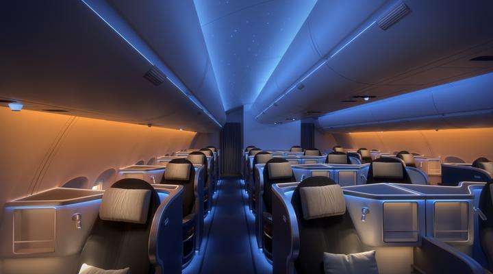 Seating area inside first class area of an aircraft cabin highlighted with blue SCHOTT mood lights