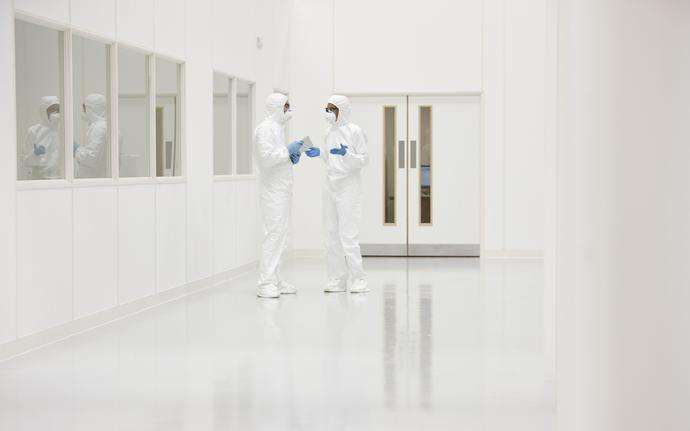 	Two scientists in protective clothing inside a cleanroom
