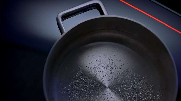 Pot of hot water on a glass-ceramic cooktop with the red light stripes of CERAN EXCITE®