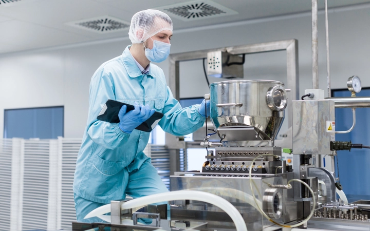 Scientist in a laboratory looking at piece of equipment