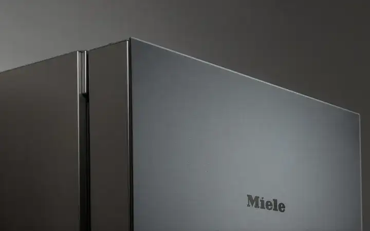Close up of a Miele refrigerator with matt black glass front